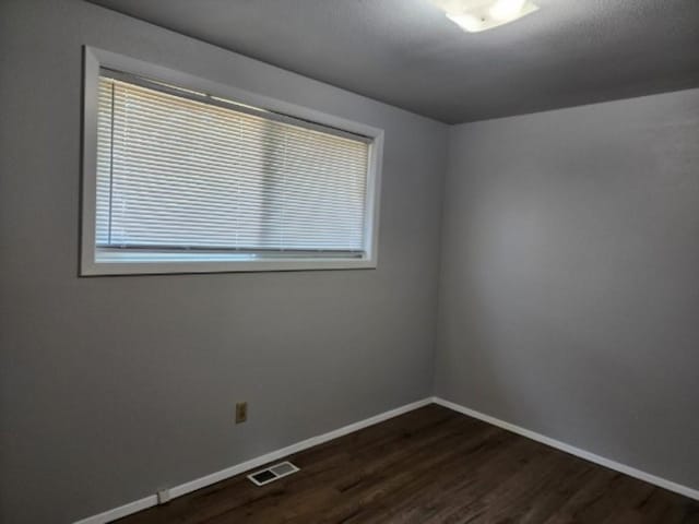 704 E Beacon Ave, Spokane, WA 99208 - empty room with baseboards and dark wood-style flooring
