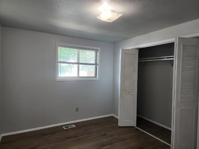704 E Beacon Ave, Spokane, WA 99208 - unfurnished bedroom with dark wood-style floors, a textured ceiling, and a closet