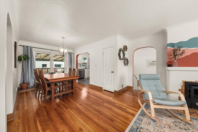 2338 W Euclid Ave, Spokane, WA 99205 - dining area featuring arched walkways, wood finished floors, a brick fireplace, and a chandelier