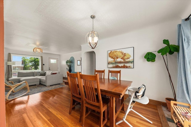 2338 W Euclid Ave, Spokane, WA 99205 - dining space with arched walkways, wood finished floors, and a chandelier