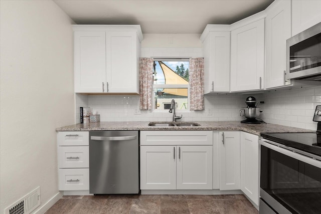 2338 W Euclid Ave, Spokane, WA 99205 - kitchen with appliances with stainless steel finishes, backsplash, white cabinetry, and light stone counters