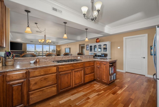 1828 W Riverside Ave Unit 301, Spokane, WA 99201 - kitchen featuring a chandelier, brown cabinets, appliances with stainless steel finishes, ornamental molding, and light wood finished floors