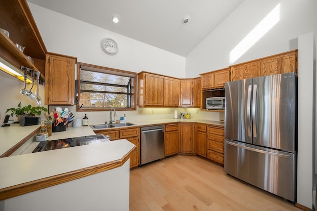 21407 W Baker Rd, Cheney, WA 99004 - kitchen with appliances with stainless steel finishes, high vaulted ceiling, light countertops, brown cabinetry, and light wood-style floors