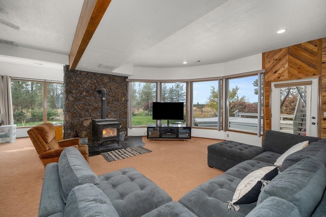 21407 W Baker Rd, Cheney, WA 99004 - living area with carpet floors, a wood stove, a textured ceiling, wooden walls, and recessed lighting