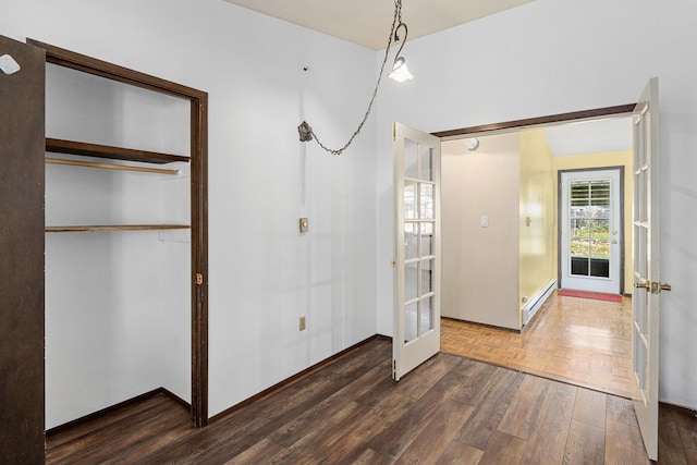 150 E 9th Ave, Kettle Falls, WA 99141 - unfurnished bedroom featuring french doors, wood finished floors, a baseboard heating unit, and a closet