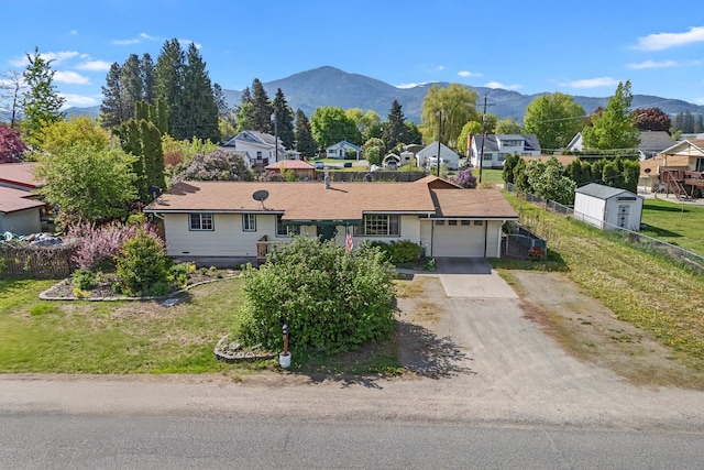 150 E 9th Ave, Kettle Falls, WA 99141 - ranch-style house with an attached garage, concrete driveway, a mountain view, and a residential view
