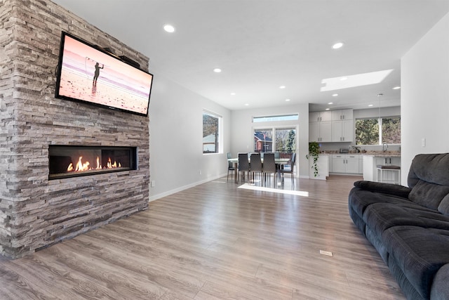 11625 N Alberta Ln, Spokane, WA 99218 - living room with light wood-style floors, a fireplace, recessed lighting, and a skylight