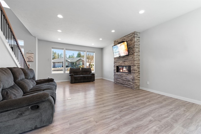 11625 N Alberta Ln, Spokane, WA 99218 - living room with light wood-type flooring, a stone fireplace, recessed lighting, and stairs