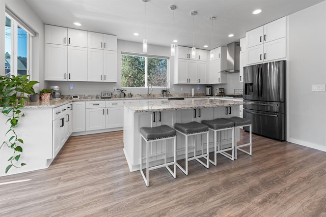 11625 N Alberta Ln, Spokane, WA 99218 - kitchen featuring appliances with stainless steel finishes, wall chimney exhaust hood, recessed lighting, a kitchen island, and white cabinets