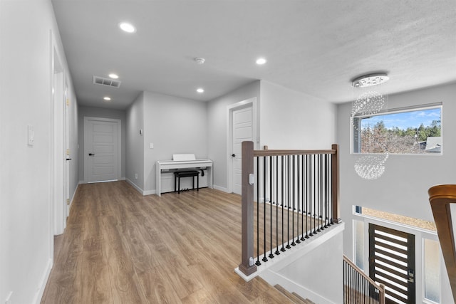 11625 N Alberta Ln, Spokane, WA 99218 - hallway featuring an upstairs landing, wood finished floors, recessed lighting, and a chandelier