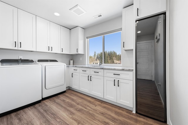 11625 N Alberta Ln, Spokane, WA 99218 - washroom featuring washing machine and dryer, cabinet space, dark wood-style flooring, and recessed lighting