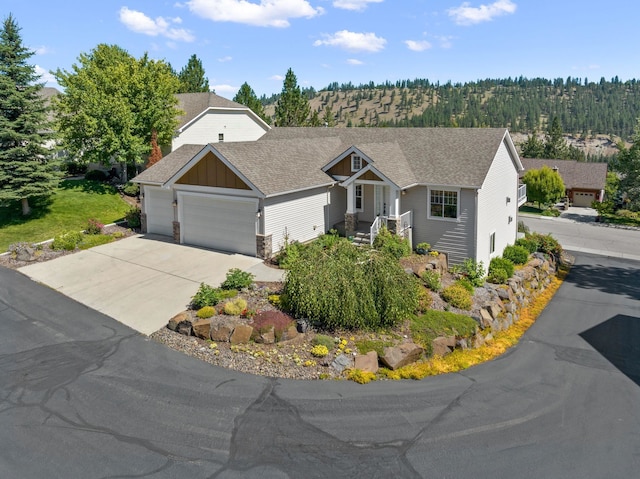 711 W Bolan Ave, Spokane, WA 99224 - view of front of property with an attached garage, board and batten siding, driveway, and a shingled roof
