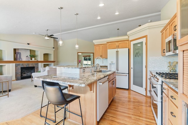 711 W Bolan Ave, Spokane, WA 99224 - kitchen with white appliances, light brown cabinetry, a fireplace, a ceiling fan, and a breakfast bar
