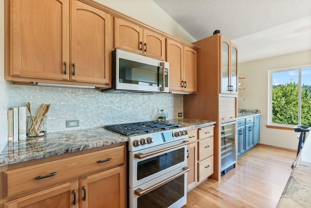 711 W Bolan Ave, Spokane, WA 99224 - kitchen featuring stainless steel microwave, double oven range, wine cooler, light wood-type flooring, and light stone counters