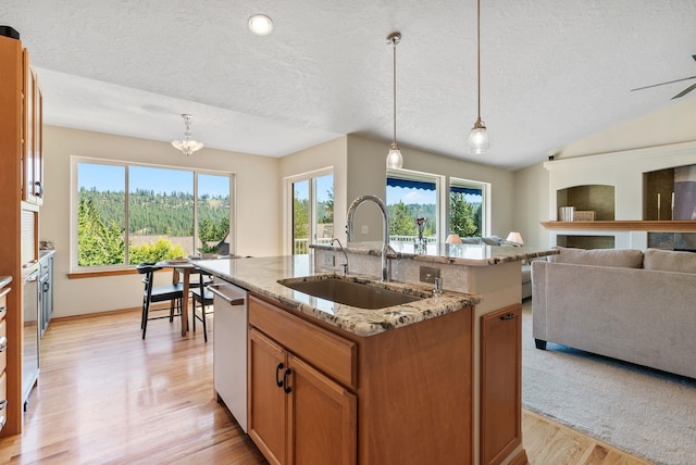 711 W Bolan Ave, Spokane, WA 99224 - kitchen featuring light wood-style floors, plenty of natural light, light stone counters, a textured ceiling, and open floor plan