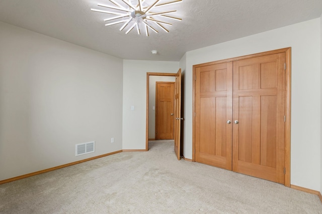 711 W Bolan Ave, Spokane, WA 99224 - unfurnished bedroom with light carpet, a closet, a textured ceiling, and a ceiling fan