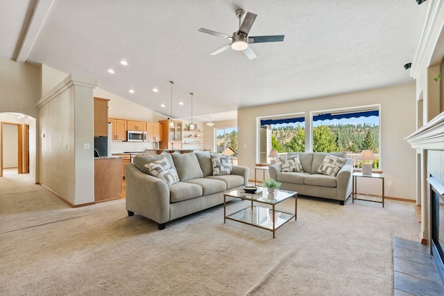 711 W Bolan Ave, Spokane, WA 99224 - living area featuring light carpet, a glass covered fireplace, a ceiling fan, arched walkways, and lofted ceiling