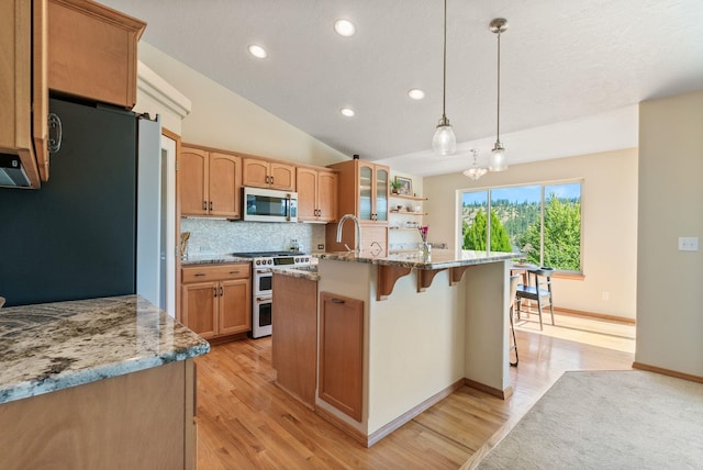 711 W Bolan Ave, Spokane, WA 99224 - kitchen featuring stainless steel microwave, range with two ovens, freestanding refrigerator, recessed lighting, and backsplash