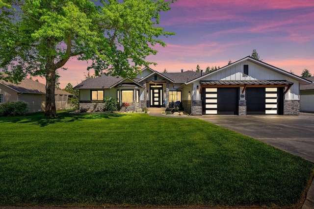 5159 W Village Blvd, Rathdrum, ID 83858 - view of front facade with stone siding, an attached garage, concrete driveway, and a front yard