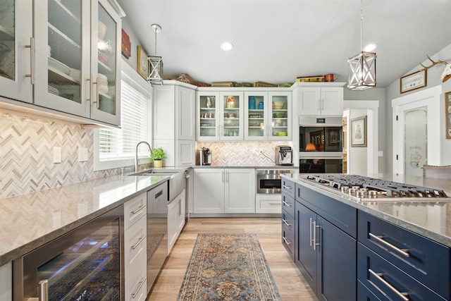 5159 W Village Blvd, Rathdrum, ID 83858 - kitchen featuring appliances with stainless steel finishes, wine cooler, blue cabinetry, white cabinetry, and recessed lighting