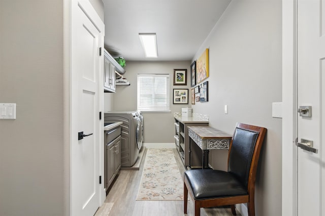 5159 W Village Blvd, Rathdrum, ID 83858 - laundry area with separate washer and dryer, light wood finished floors, and cabinet space