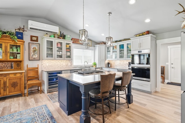 5159 W Village Blvd, Rathdrum, ID 83858 - kitchen with wine cooler, a wall unit AC, lofted ceiling, backsplash, and light wood-type flooring