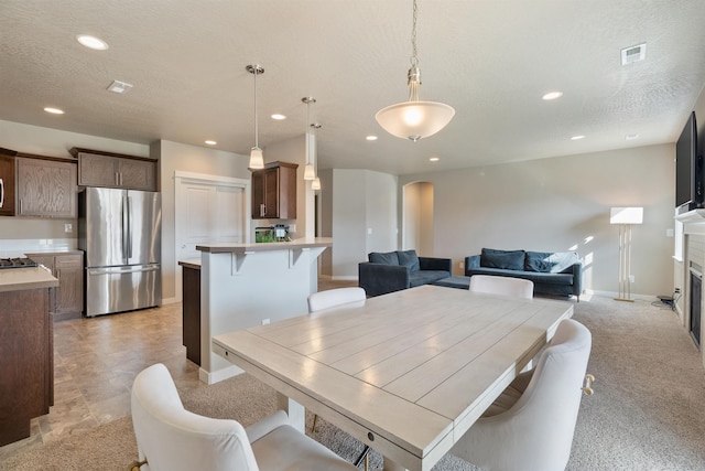 1101 S Pillar Rock Dr, Spokane, WA 99224 - dining room with arched walkways, recessed lighting, a textured ceiling, and a glass covered fireplace