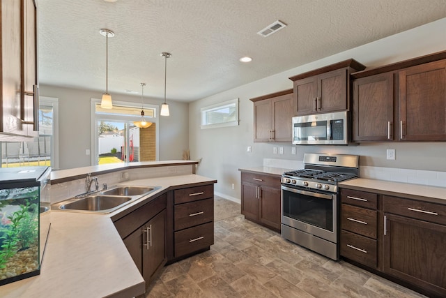 1101 S Pillar Rock Dr, Spokane, WA 99224 - kitchen with appliances with stainless steel finishes, dark brown cabinetry, a textured ceiling, decorative light fixtures, and light countertops