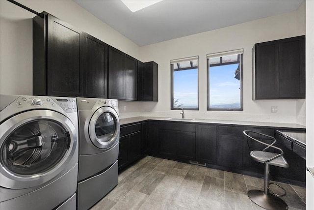 2503 S Thierman Ln, Spokane, WA 99223 - laundry room with cabinet space, washer and clothes dryer, and light wood-style flooring
