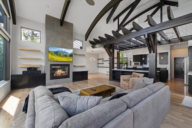 2503 S Thierman Ln, Spokane, WA 99223 - living room featuring high vaulted ceiling, a tiled fireplace, beamed ceiling, and light wood-style flooring