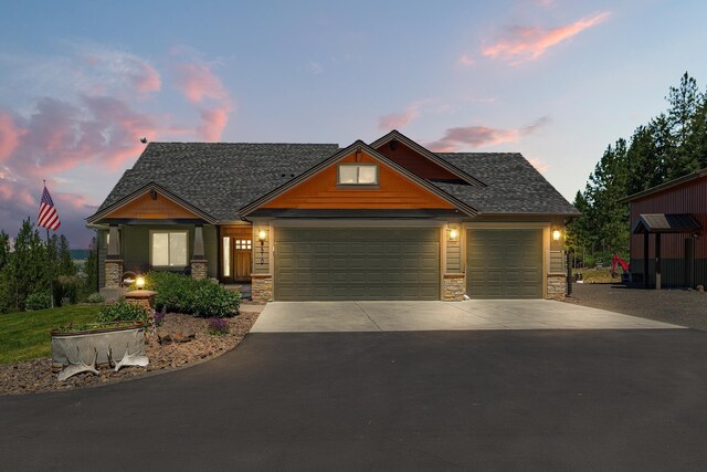 9510 N Doak Rd, Spokane, WA 99217 - craftsman house with stone siding, driveway, a garage, and roof with shingles