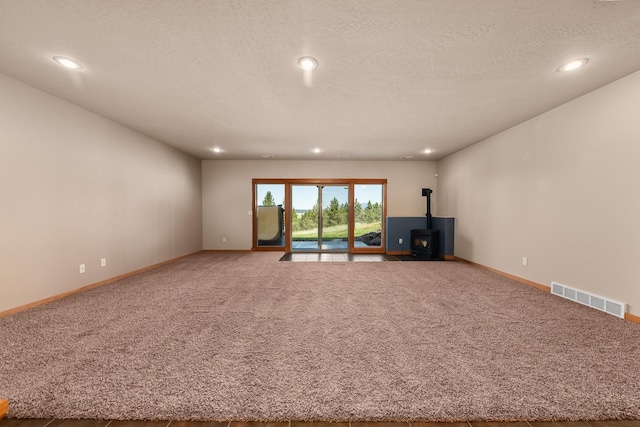 9510 N Doak Rd, Spokane, WA 99217 - unfurnished living room with a wood stove, carpet, recessed lighting, and a textured ceiling