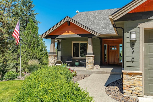 9510 N Doak Rd, Spokane, WA 99217 - view of exterior entry featuring a porch, stone siding, and roof with shingles