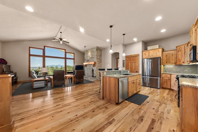 9510 N Doak Rd, Spokane, WA 99217 - kitchen featuring appliances with stainless steel finishes, open floor plan, light wood finished floors, a stone fireplace, and ceiling fan