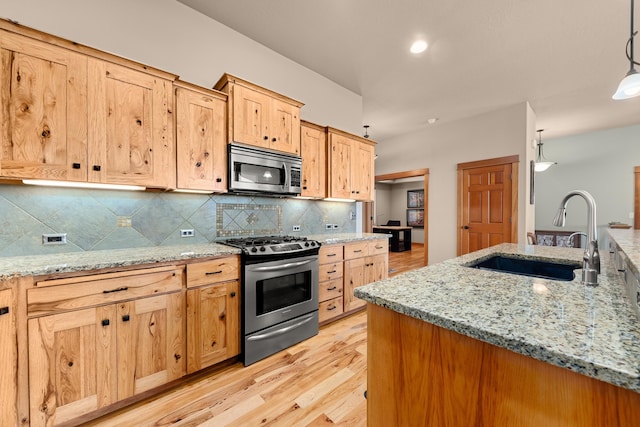 9510 N Doak Rd, Spokane, WA 99217 - kitchen with appliances with stainless steel finishes, backsplash, light wood-style flooring, and light stone counters