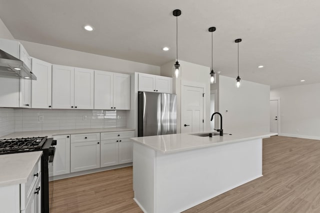 L4 E Sharp Ln, Spokane Valley, WA 99206 - kitchen with freestanding refrigerator, black gas stove, light wood-style flooring, tasteful backsplash, and recessed lighting