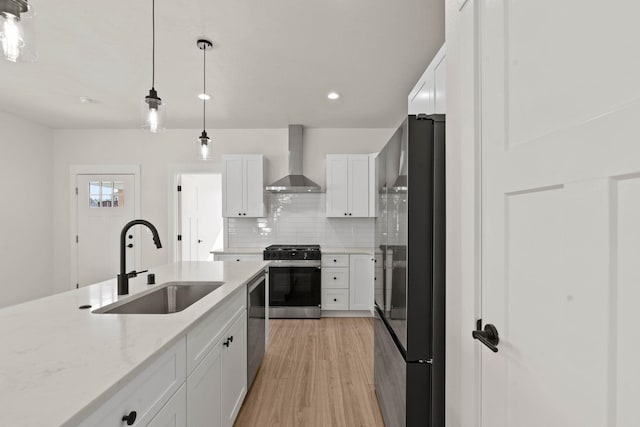 L4 E Sharp Ln, Spokane Valley, WA 99206 - kitchen with stainless steel appliances, wall chimney range hood, light wood-style flooring, decorative backsplash, and white cabinetry