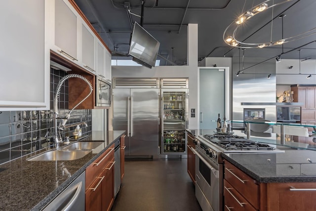 2230 W Riverside Ave # 302, Spokane, WA 99201 - kitchen featuring high quality appliances, tasteful backsplash, dark stone countertops, white cabinets, and finished concrete flooring