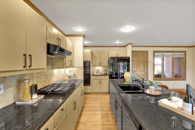 4402 S Saint Andrews Ln, Spokane, WA 99223 - kitchen featuring under cabinet range hood, black appliances, cream cabinets, ornamental molding, and light wood-style flooring