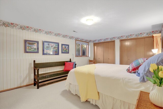 4402 S Saint Andrews Ln, Spokane, WA 99223 - carpeted bedroom featuring two closets and wallpapered walls