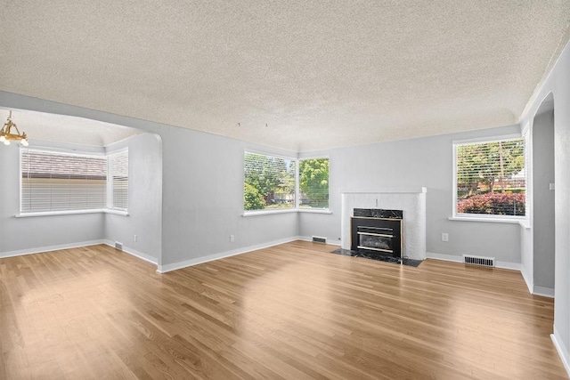 3307 W Euclid Ave, Spokane, WA 99205 - unfurnished living room featuring a textured ceiling, light wood-type flooring, and a premium fireplace