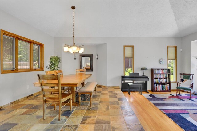 10612 E 46th Ave, Spokane Valley, WA 99206 - dining area with healthy amount of natural light, stone finish flooring, a chandelier, and a textured ceiling