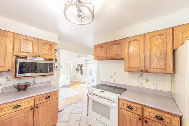 1018 N Fox Rd, Spokane Valley, WA 99206 - kitchen featuring white appliances, tasteful backsplash, and light countertops