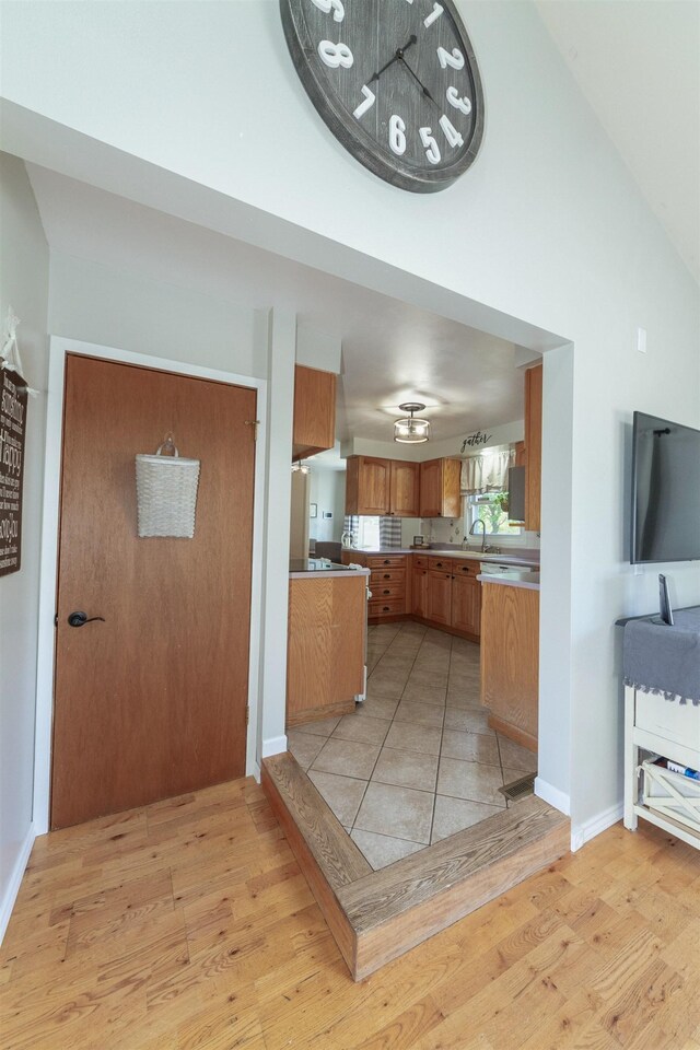 1018 N Fox Rd, Spokane Valley, WA 99206 - kitchen featuring light wood-style floors, brown cabinets, a towering ceiling, light countertops, and open floor plan