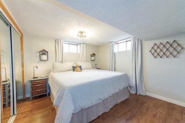 1018 N Fox Rd, Spokane Valley, WA 99206 - bedroom featuring wood finished floors, a closet, multiple windows, and a textured ceiling