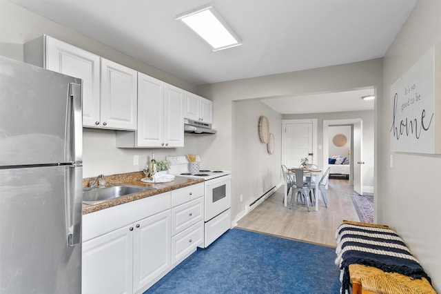 1023 W Maxwell Ave, Spokane, WA 99201 - kitchen featuring freestanding refrigerator, electric range, under cabinet range hood, a baseboard radiator, and white cabinetry