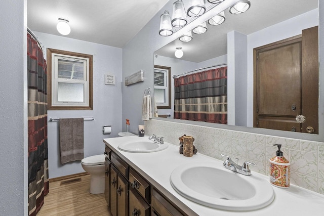 15906 N Forker Rd, Spokane, WA 99217 - full bath with double vanity, backsplash, wood finished floors, and a shower with shower curtain