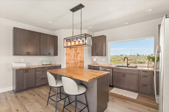 25751 Westfield Ln, Davenport, WA 99122 - kitchen featuring wood counters, dishwasher, a breakfast bar area, light wood-style floors, and recessed lighting