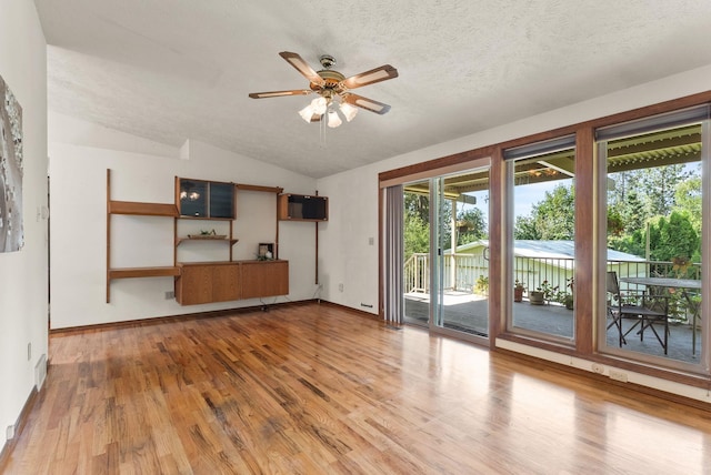 3827 E Funk Ave, Spokane, WA 99223 - unfurnished living room featuring wood finished floors, ceiling fan, vaulted ceiling, and a textured ceiling