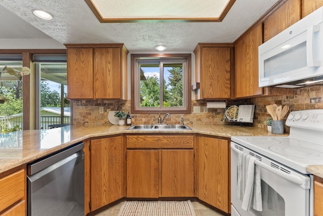 3827 E Funk Ave, Spokane, WA 99223 - kitchen featuring white appliances, a textured ceiling, healthy amount of natural light, and backsplash
